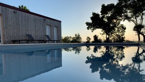 A swimming pool with a wooden building and lounge chairs in the background. - A SPIRIT OF FAMILY **** (4 ears) (Faudoas)