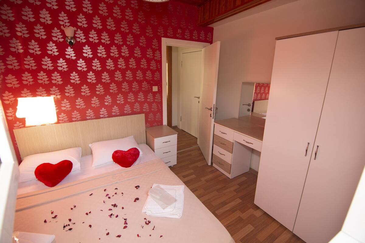 Ein Schlafzimmer mit Bett, Schreibtisch und Kleiderschrank.
