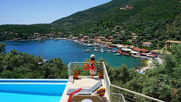 A poolside view overlooking a marina with boats, surrounded by houses and greenery. - Ktima Aniforeli Luxury Villas (Lefkada)