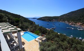 A pool with a view of a marina and surrounding hills.