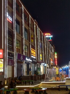 Un edificio de varios pisos con señalización iluminada para distintos negocios, incluyendo un restaurante y un hotel.