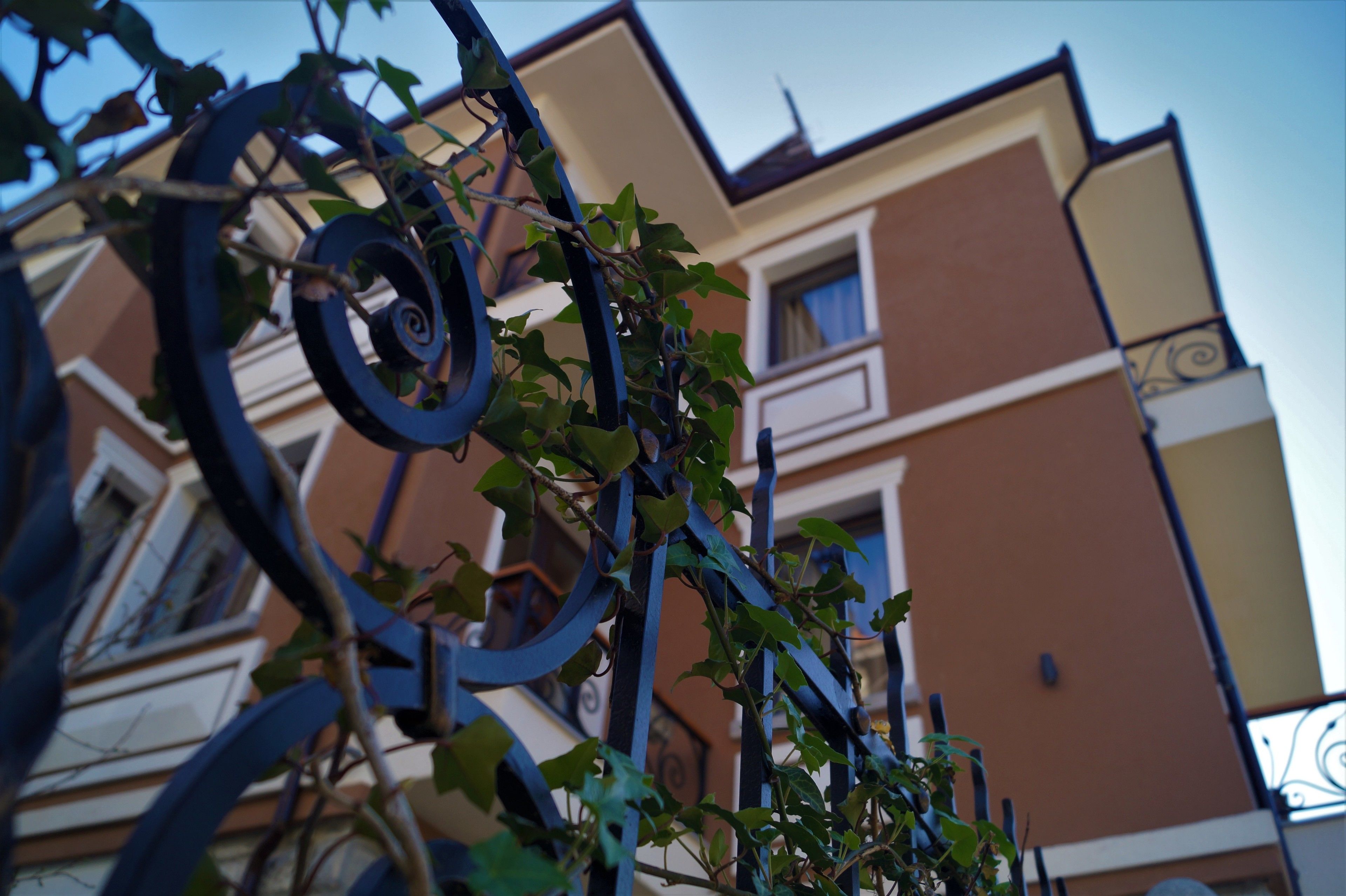 A building with a brown facade and a balcony with a wrought iron railing.