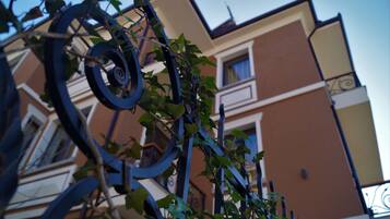 A building with a brown facade and a balcony with a wrought iron railing.