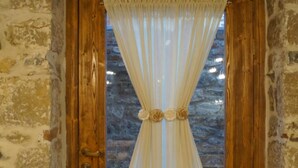 A wooden door with a white curtain featuring a floral design. - Vila Trebicka (Korçë)
