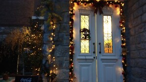 A double door with decorative lights and a Coca-Cola sign in front. - Vila Trebicka (Korçë)