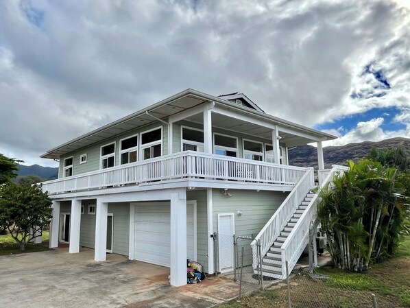 A two-story house with a balcony, a garage, and a staircase leading to the upper level.