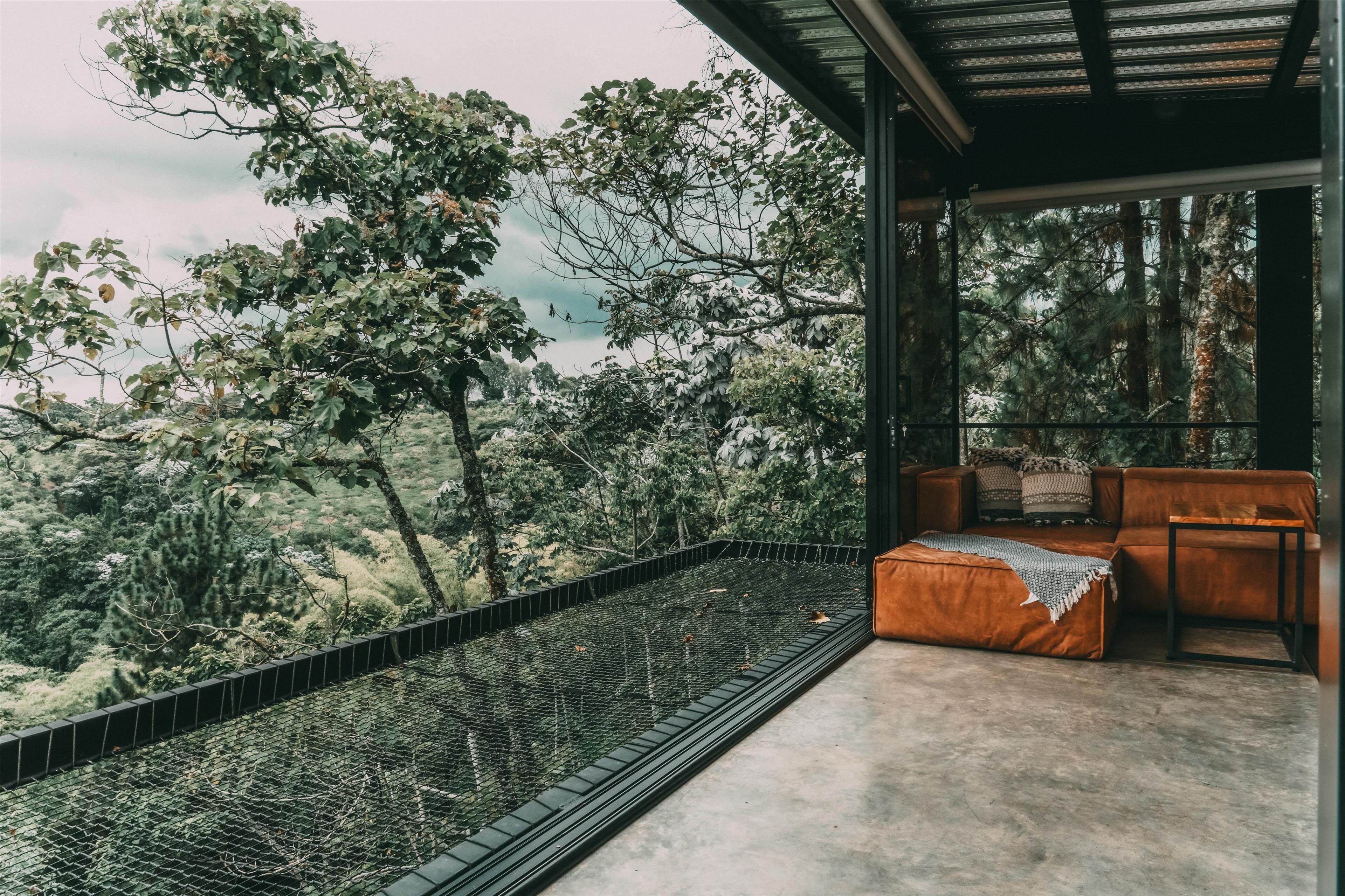Un espacio de estar moderno al aire libre con vistas a un paisaje boscoso.