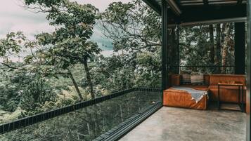 A modern outdoor seating area with a view of a forested landscape.