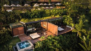 A modern outdoor living area with a glass-enclosed patio, lounge chairs, and a hot tub. - Bio Habitat Hotel, AKEN SOUL Collection (Circasia)