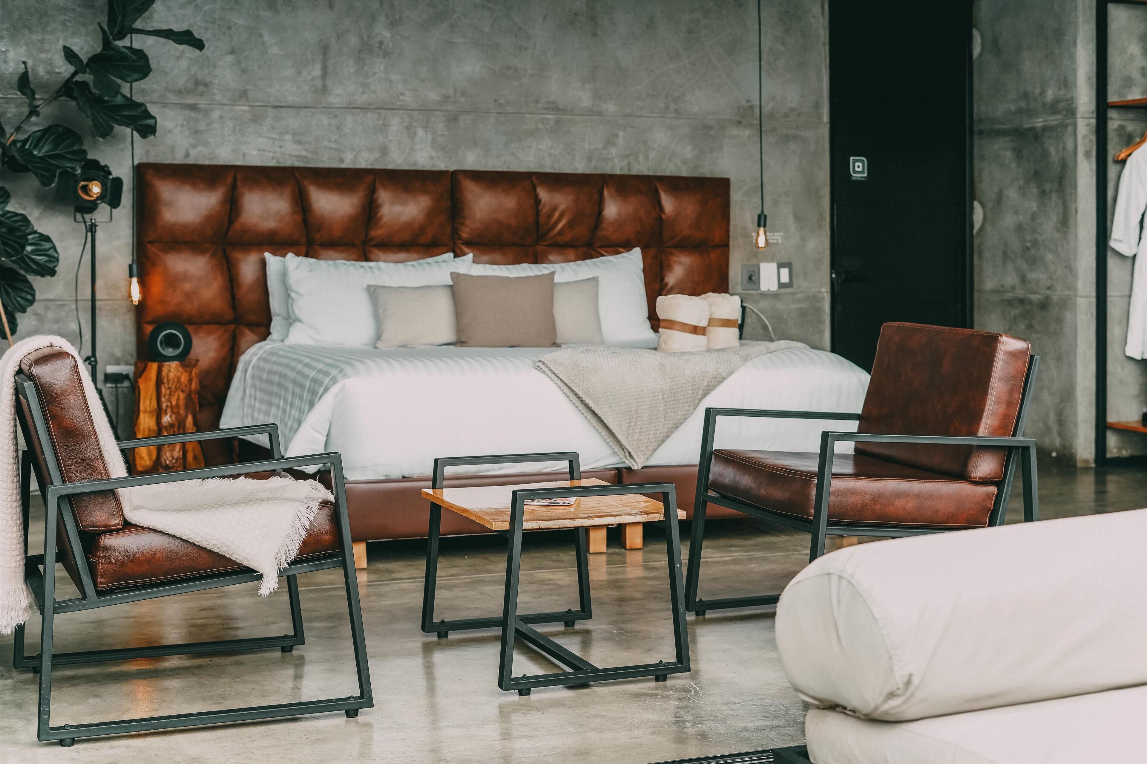 Un dormitorio moderno con una cama grande, sillones de cuero y un diseño minimalista.