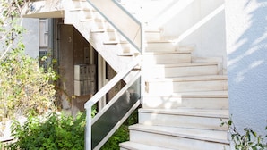 A staircase leading to an upper floor, surrounded by potted plants and a clear sky. - Fabulous Apartment Across Flisvos (Palaio Faliro)