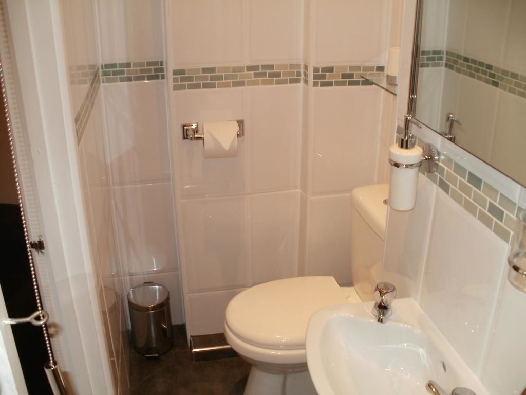 A bathroom with a toilet, sink, and shower area.