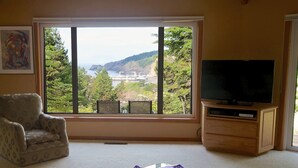 A living room with a large window, a television, and a patterned armchair. - Battle Rock House-Port Orford - Spectacular Views
No Wind
Broadband Internet (Port Orford)