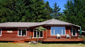 A wooden cabin with a tiled roof, large windows, and a covered porch with outdoor seating. - Battle Rock House-Port Orford - Spectacular Views
No Wind
Broadband Internet (Port Orford)