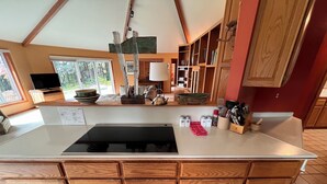 A kitchen with wooden cabinets, a black stove, and a window with a view of trees. - Battle Rock House-Port Orford - Spectacular Views
No Wind
Broadband Internet (Port Orford)