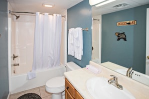Un baño con bañera, inodoro y lavamanos.