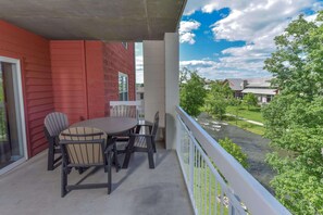 A balcony with a table and chairs, overlooking a river and greenery. - Bear Crossing 301 (Pigeon Forge)