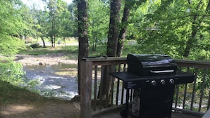 Una terrassa amb una barbacoa portàtil i vista a un riu.