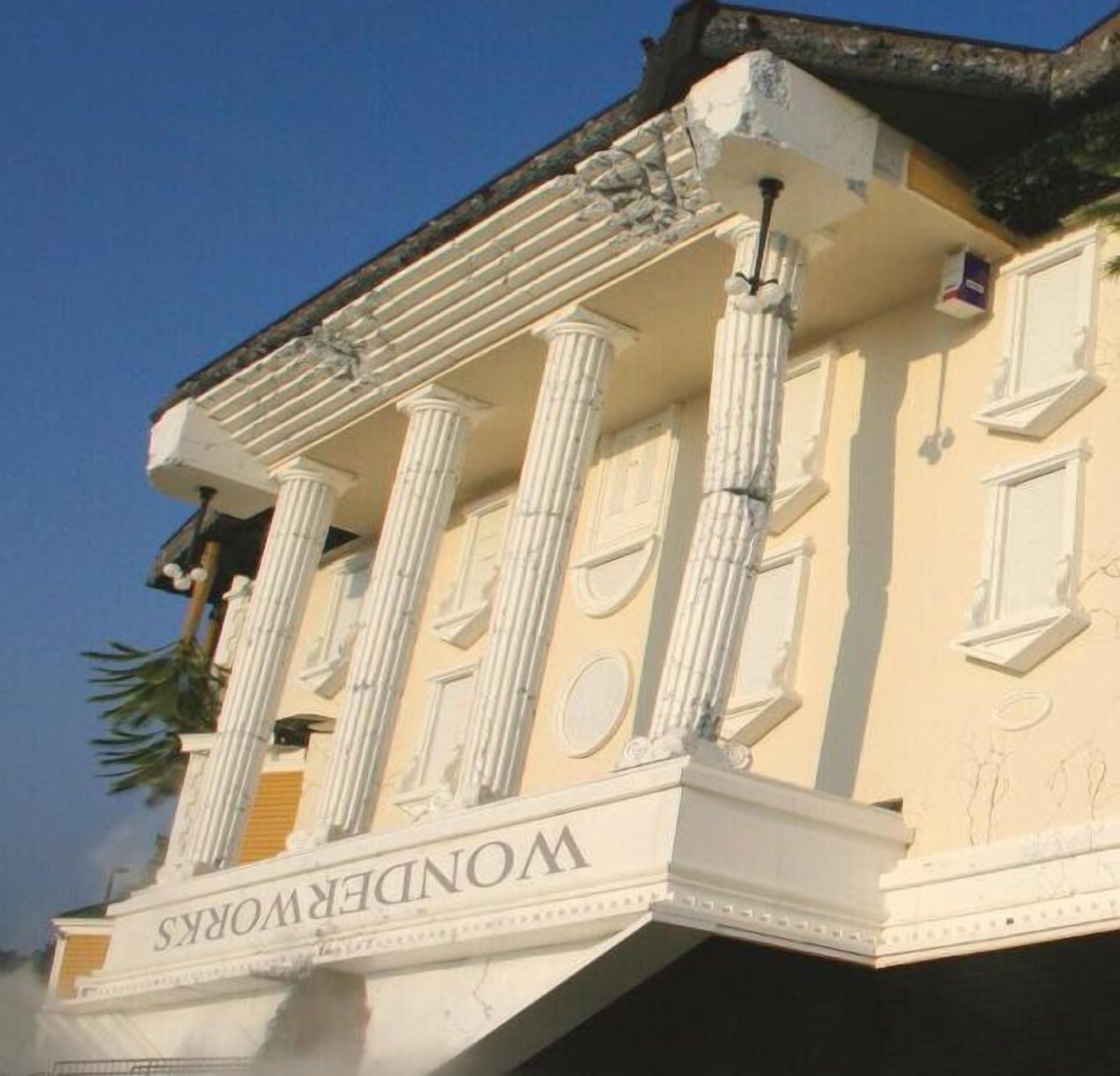 A building with classical architecture, featuring columns and a balcony with the inscription "WONDERS."
