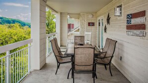 Eine Terrasse im Freien mit Tisch, Stühlen, einem Geländer und dekorativen Wandelementen.
