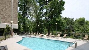 A swimming pool with lounge chairs and a building in the background.