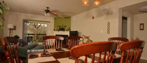 A dining area with a wooden table, chairs, and a ceiling fan.