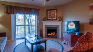 Una sala de estar con chimenea, televisor y sofá.