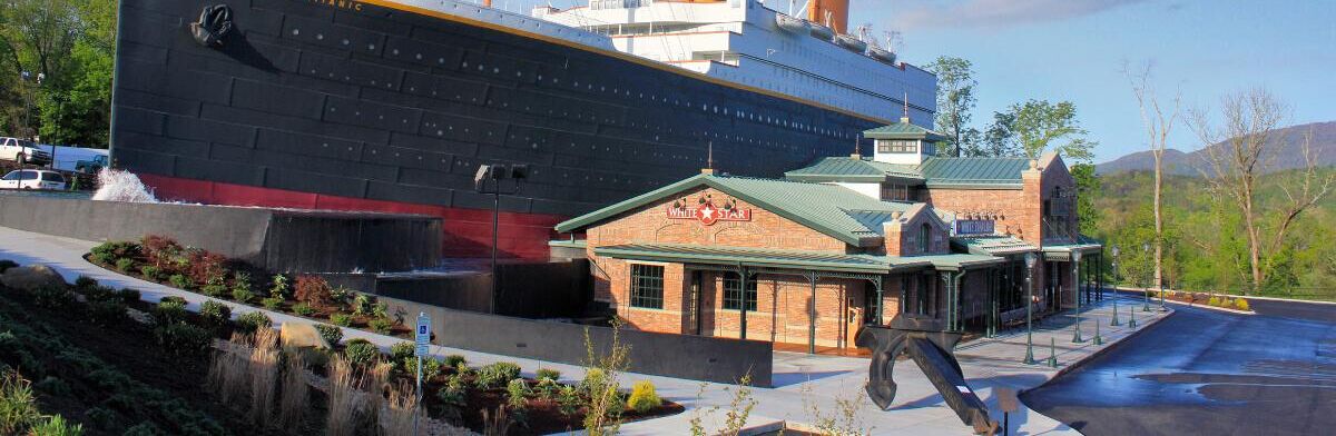 A large cruise ship docked at a port with a small brick building labeled "WHITE STAR" nearby.