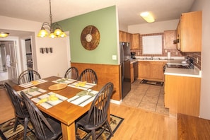Enjoy meals in this dining area with a table for four and a large clock on the wall.