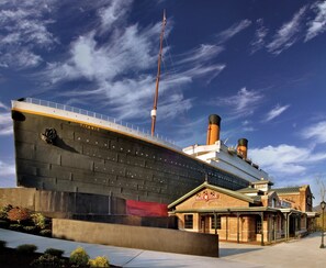 A large ship with the name "TITANIC" on its side, docked at a port with a building labeled "WHITE STAR" nearby. - Cedar Lodge 402 (Pigeon Forge)