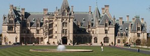 Un grand bâtiment historique doté d’une entrée monumentale, d’une cour intérieure et d’une façade symétrique.