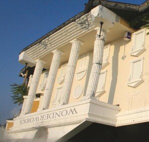 Ein Gebäude mit klassischer Architektur, das Säulen und einen Balkon zeigt.