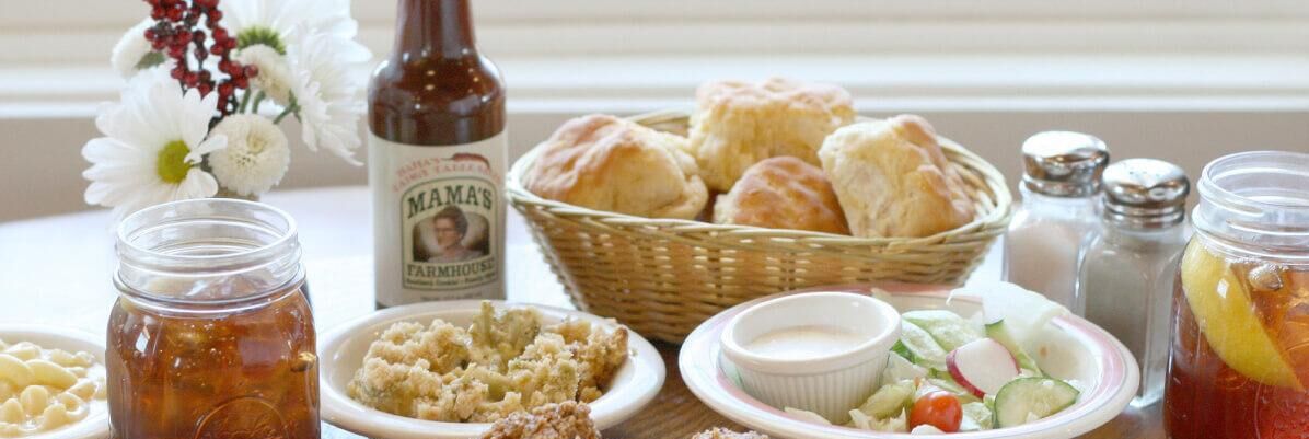 A table with various food items, including biscuits, salad, and a bottle of sauce.