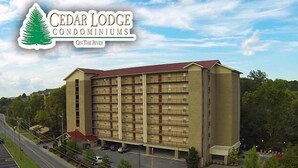 A large, multi-story building with a flat roof and a parking lot in front.
