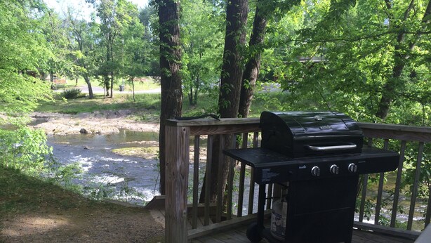 A deck with a portable grill and a view of a river. - Cedar Lodge 605 (Pigeon Forge)
