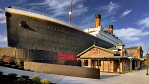 A large ship with the name "TITANIC" on its side, docked next to a building labeled "WHITE STAR." - Cedar Lodge 605 (Pigeon Forge)