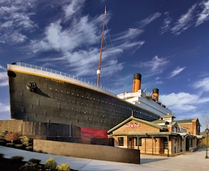 A large cruise ship docked at a port with a building labeled "White Star" nearby.