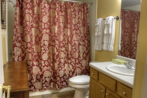 Une salle de bain équipée de toilettes, d’un lavabo et d’un rideau de douche.