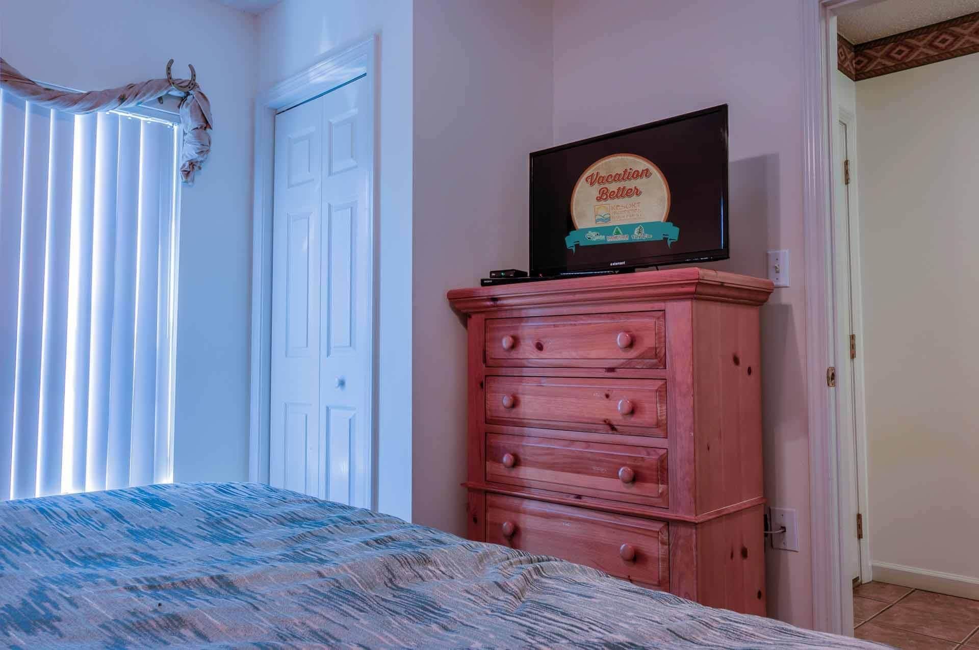 Ein Schlafzimmer mit einem Bett, einem Schminktisch, einem gerahmten Schild an der Wand und einer Tür.