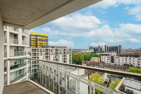 A modern apartment building with multiple balconies and a view of the cityscape.