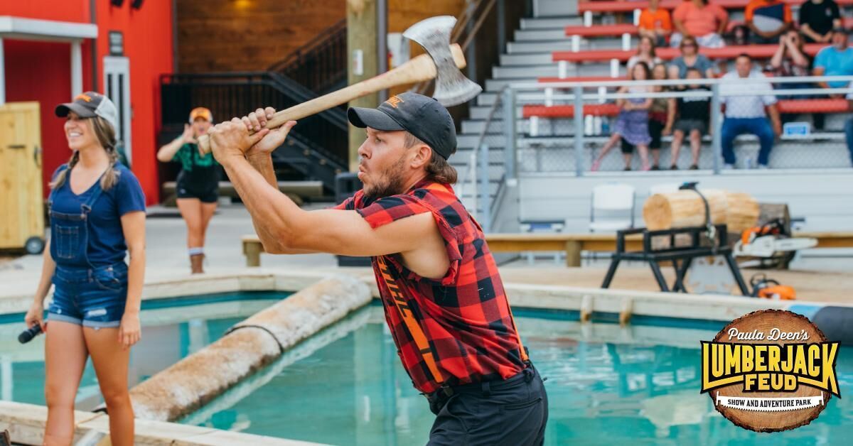 A person holding a large axe near a pool, with spectators in the background.