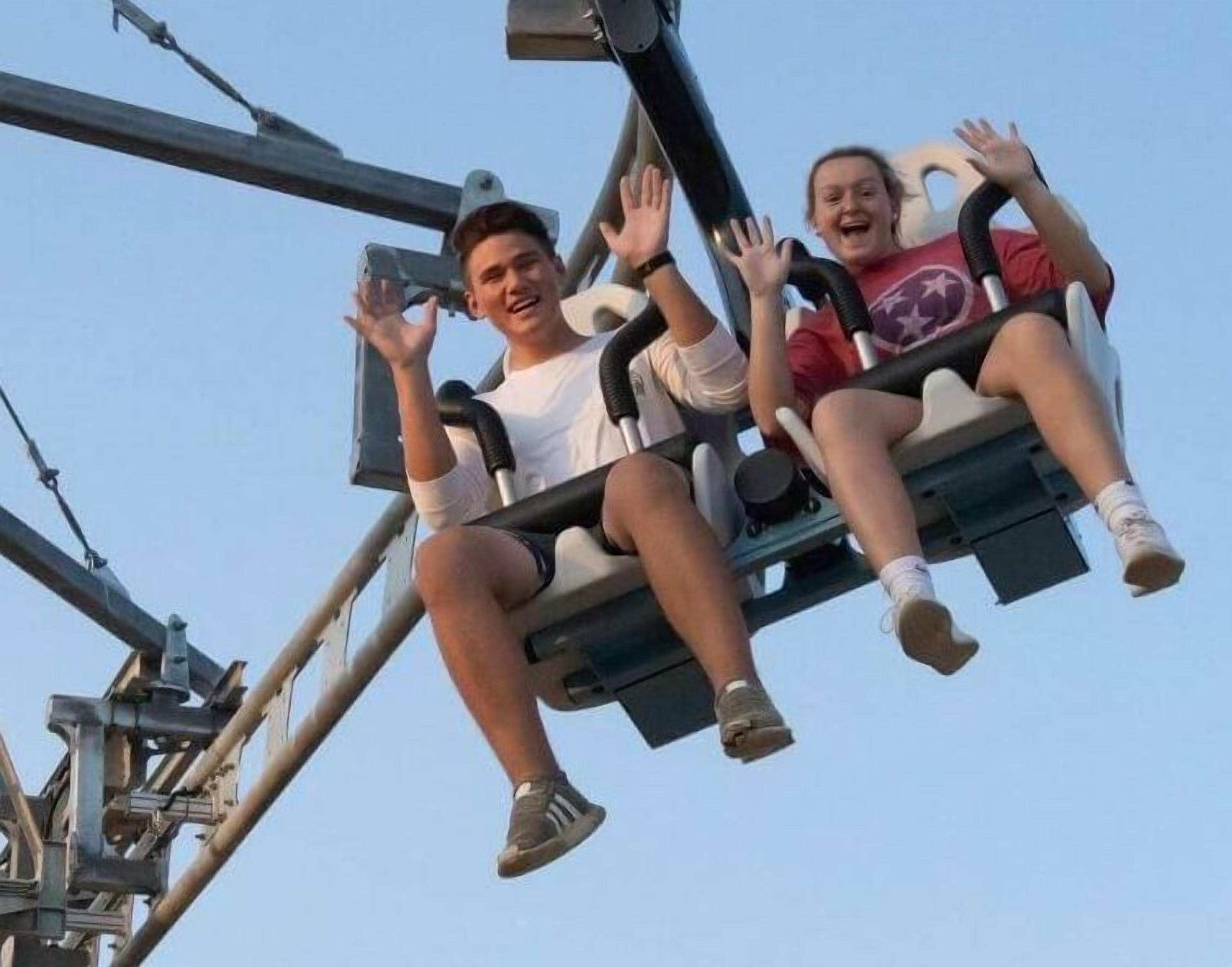 Two people on a swing ride at an amusement park.