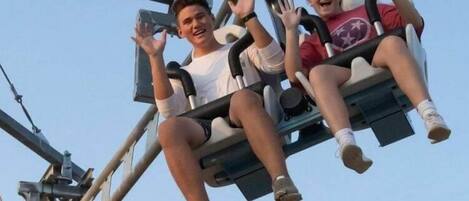 Two people on a swing ride at an amusement park.