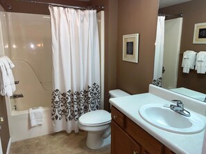 A bathroom with a shower, toilet, and sink. - Whispering Pines 252 (Pigeon Forge)