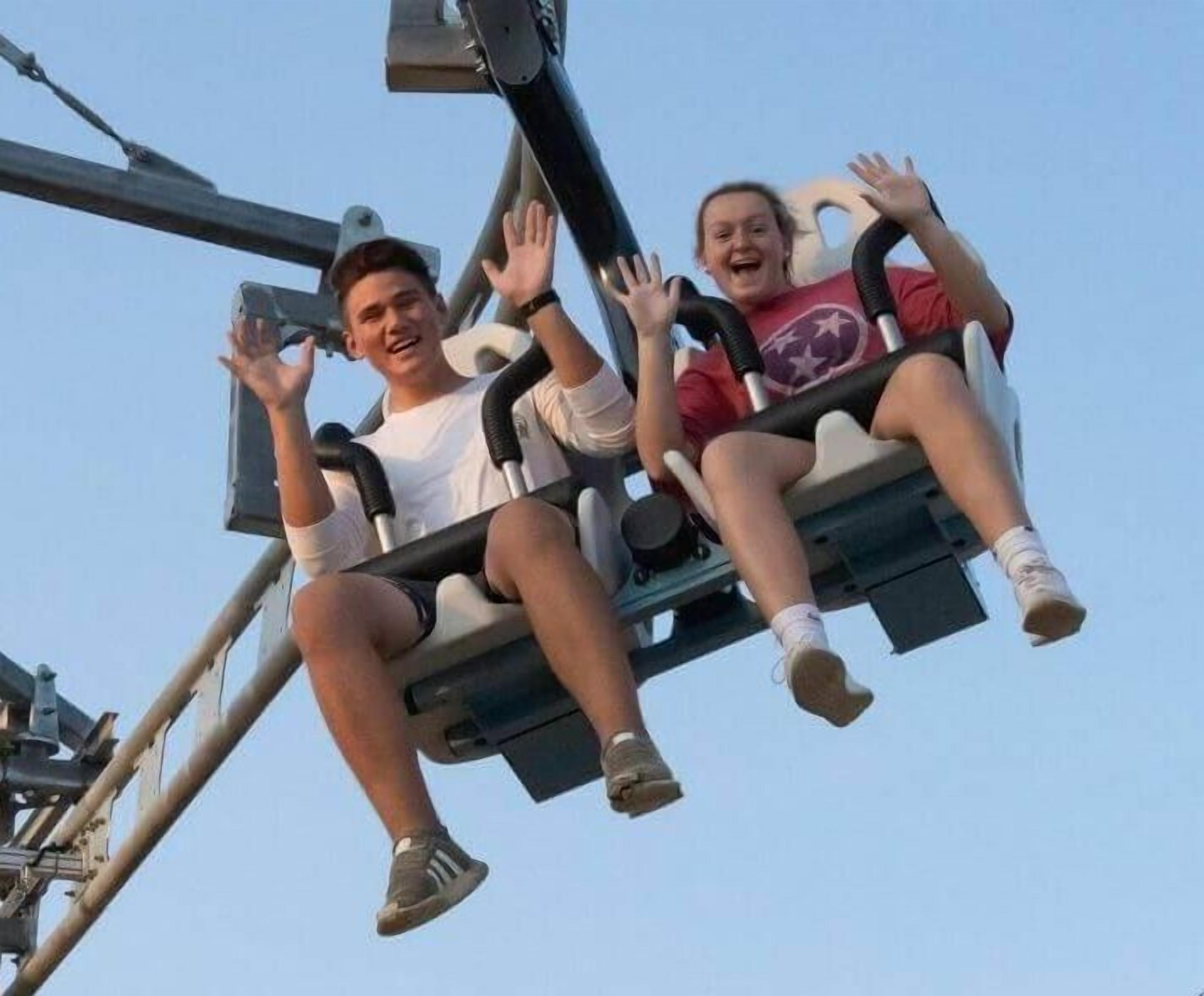 Two people on a swing ride at an amusement park.