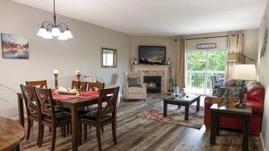 A living room with a fireplace, dining area, and a red sofa.