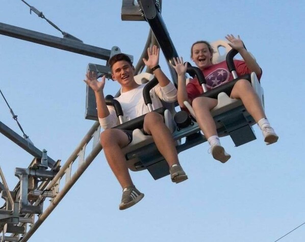 Two people on a swing ride at an amusement park. - Whispering Pines 313 (Pigeon Forge)