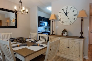 Enjoy meals in this stylish dining area with a large clock, chandelier, and fully equipped kitchen.