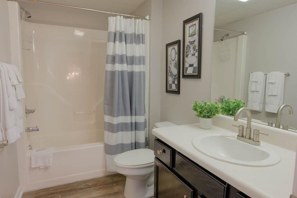 A modern bathroom with a shower, toilet, and sink.