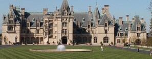 Un grand bâtiment historique à la façade symétrique, doté de plusieurs tours et d’une entrée centrale.